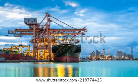 Industrial Container Cargo freight ship with working crane bridge in shipyard at dusk for Logistic Import Export background Royalty-Free Stock Photo #218774425