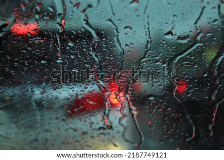 water droplets on the windshield  caused by heavy rain  The poor visibility may cause danger in driving the vehicle.