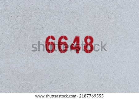Red Number 6648 on the white wall. Spray paint.
