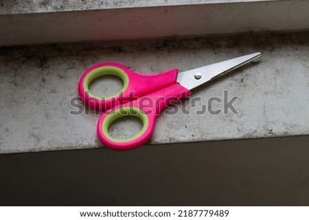 scissors that are placed in a white but dirty place
