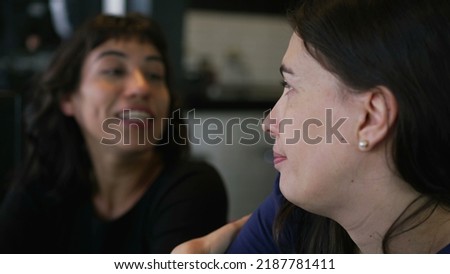 Female friends talking at restaurant chatting. Two women in conversation
