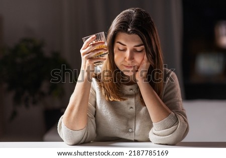 alcoholism, alcohol addiction and people concept - drunk woman or female alcoholic drinking whiskey at home Royalty-Free Stock Photo #2187785169