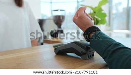 Man hand with smartwatch using terminal for payment, non-cash transaction, side view. Non-cash payment concept. Pos-terminal on table on black background. Royalty-Free Stock Photo #2187791101