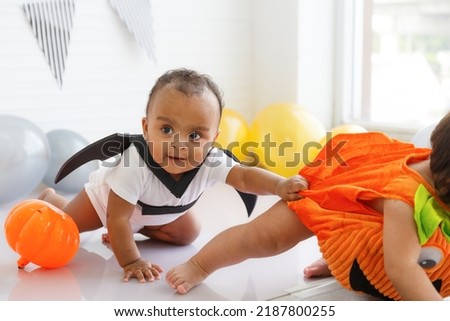 girl, Halloween toddler in Dracula costume, sitting, white background, with balloons, inside festive concept house Holidays and childhood, Halloween decorations and lifestyle in the home. copy space