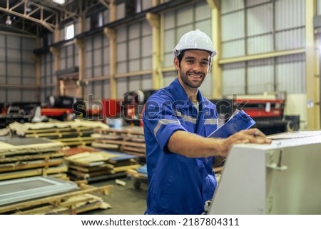 Portrait of Caucasian man industry worker working in factory warehouse. Attractive male industrial engineer processes orders and products alone at manufacturing plant then looking at camera with smile Royalty-Free Stock Photo #2187804311