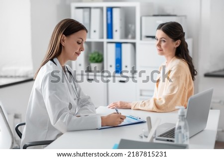 medicine, healthcare and people concept - female doctor with clipboard talking to woman patient at hospital Royalty-Free Stock Photo #2187815231