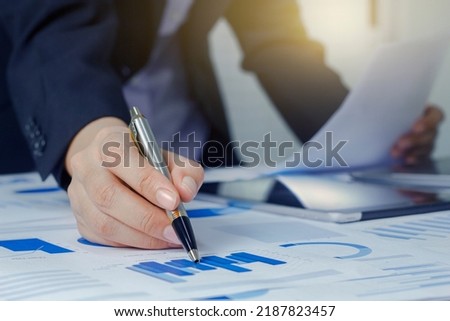 Close up business woman hand working analisys data with business graph information diagram on office desk as concept in morning light Royalty-Free Stock Photo #2187823457