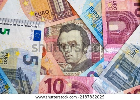 Bright background of euro and Ukrainian hryvnia banknotes with a portrait of Taras Shevchenko. Close-up