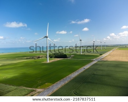 Aerial view on modern wind mills, green grain fields and blue Atlantic ocean in agricultural region Pays de Caux in Normandy, France in summer Royalty-Free Stock Photo #2187837511