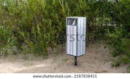 A white garbage container on the Baltic Sea beach. Latvia.