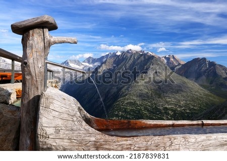 Beautiful wooden water fountain in the Austrian Alps, Europe Royalty-Free Stock Photo #2187839831