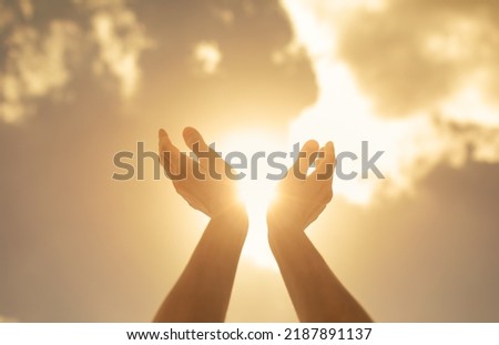 Worshiping hands up to the bright golden sunlight  Royalty-Free Stock Photo #2187891137