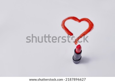 Red lipstick and drawn heart on white background. Love or valentines day concept.