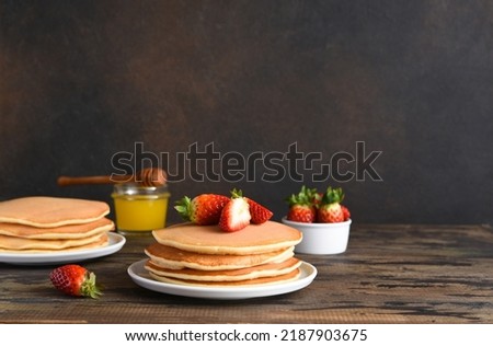 Homemade pancakes with strawberries and blueberries for breakfast. American dessert