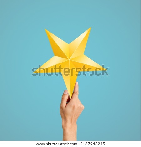 Successful and Talent Concept, Hand Raise up a Golden Star on color background
