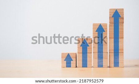 Increasing of blue up arrow on wooden cube block with copy space for business investment growth and career path success concept.