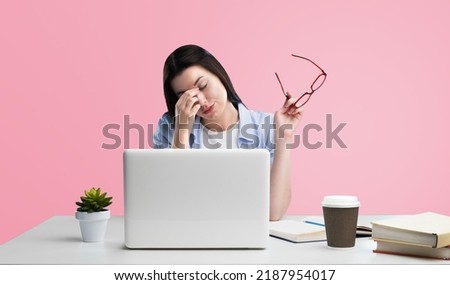 Young women stress from overwork on a pastel pink background.