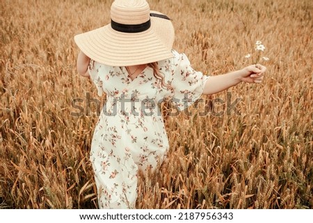 Woman field wheat. Happy young woman in sun hat in summer wheat field at sunset. Nature, summer holidays, vacation and people concept.