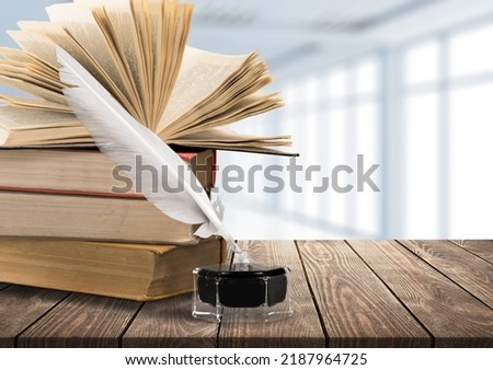 Stack of old antique books, inkwell with quill pen. Royalty-Free Stock Photo #2187964725