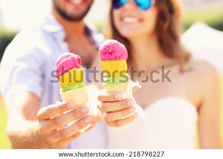 A picture of a happy couple showing ice-cream cones