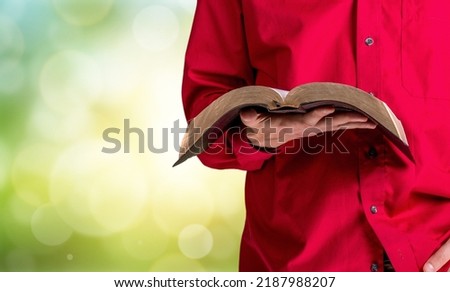 Human with a Bible in his hand during a sermon. The preacher delivers Royalty-Free Stock Photo #2187988207