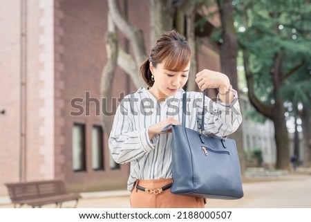 casual business office worker looking inside bag Royalty-Free Stock Photo #2188000507
