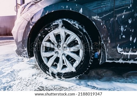Tires and wheels of a car at a self-service car wash close-up.