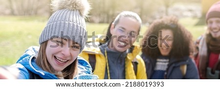 Group of happy hikers with backpacks taking selfie portrait on countryside - Smiling happy climbing tourists enjoying holidays in the mountain - Freedom and sport concept - Selective focus 