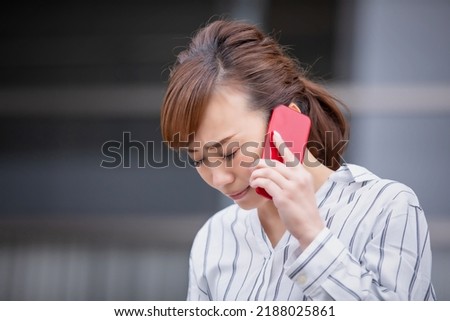 Asian business woman apologizing while calling on smartphone Royalty-Free Stock Photo #2188025861