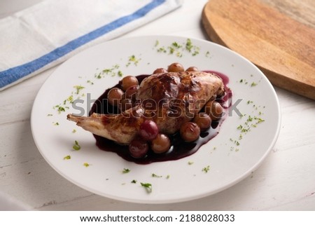 Baked rabbit with red wine sauce and grapes.