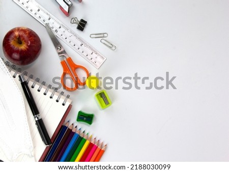 Education elements concepts, color pencils, face mask, paper clips, scissors, ruler, apple isolated on white background. Back to school concept 