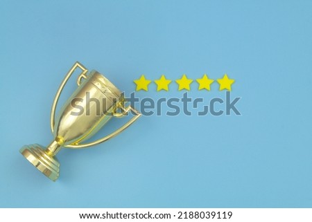 Gold trophy cup with five yellow stars on blue background.
