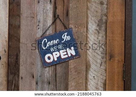 Come in we are Open sign hanging on door at cafe.
