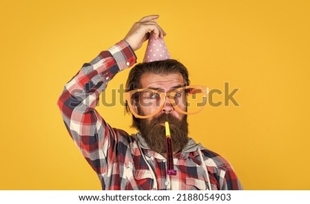 having funny look. bearded man celebrate holiday. anniversary. surprise for him. event manager with gift. mature guy in checkered shirt with party hat. stylish male having fun on birthday Royalty-Free Stock Photo #2188054903