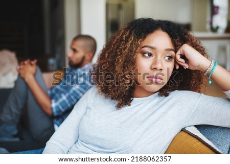 Unhappy couple and sad woman upset after argument or conflict with her man on home sofa. Angry girlfriend or female thinking about disagreement or ignoring partner, tired of relationship problems. Royalty-Free Stock Photo #2188062357