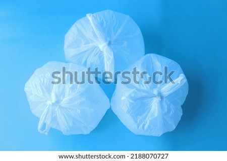 Collection of white disposable plastic bags on blue background.