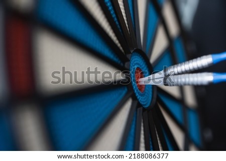A dart hitting the center of target with copy space in dramatic light and shadow. Bullseye target or a dart dashboard for financial business planning and targeting with winner goal concept