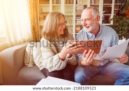 Couple of seniors planning pension investment as retirement provision at home on the tablet computer Royalty-Free Stock Photo #2188109521