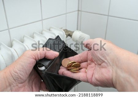 elderly hands counting a few coins in front of an old heater, people with low income or pension suffers energy crisis and inflation, copy space, selected focus, narrow depth of field Royalty-Free Stock Photo #2188118899