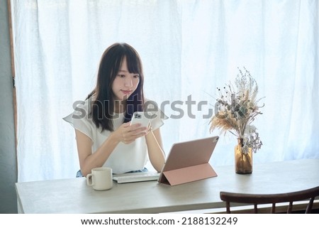 A woman who puts a tablet PC and operates a smartphone