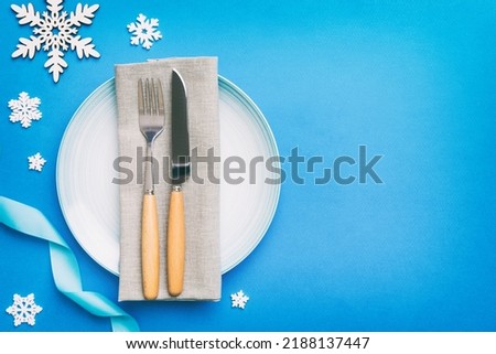 Christmas table place setting with christmas decor and plates, kine, fork and spoon. Christmas holiday background. Top view with copy space.