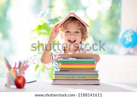 Kids go back to school. Children study and learn for preschool. Little boy of elementary class doing homework. Bedroom with desk, books and globe for young child. Kid learning to read and write. Royalty-Free Stock Photo #2188141611
