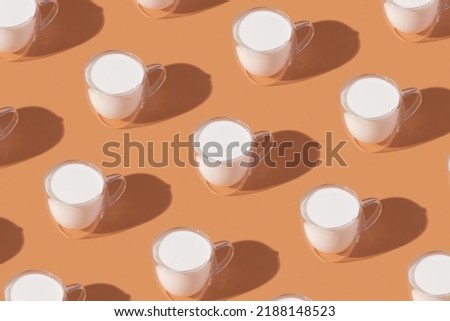 Milk in a glass pattern on a orange colored background, dairy diet concept . High quality photo