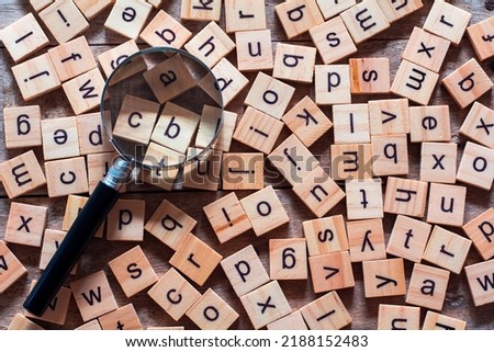 English alphabet made of square wooden tiles with the English alphabet scattered on wood background. The concept of thinking development,grammar.