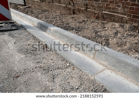 Normandy, France, JAugust 2022. Sidewalk and gutter repair in a street. Installation of cement curbs