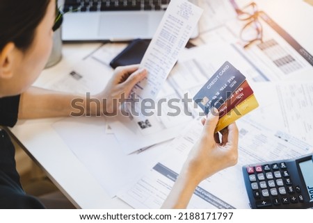 Sad Asian woman looking at many credit cards in her hand and worried about loan debt pay late. Royalty-Free Stock Photo #2188171797