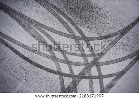 Top angle view of snow covered asphalt parking lot with curved and straight wheel traces, South Korea 
 Royalty-Free Stock Photo #2188171907