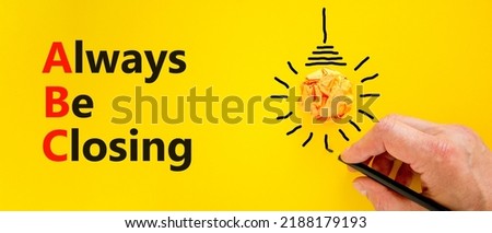 ABC always be closing symbol. Concept words ABC always be closing on a beautiful yellow background. Orange light bulb icon. Businessman hand. Business and ABC always be closing concept. Copy space.