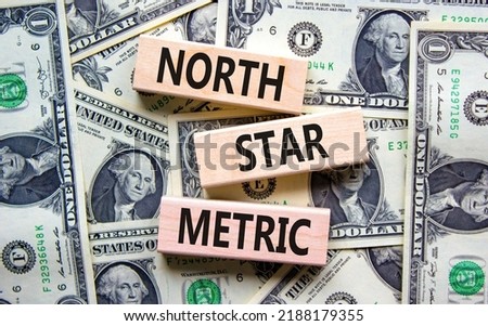 North star metric symbol. Concept words North star metric on wooden blocks on a beautiful background from dollar bills. Business finacial and north star metric concept. Copy space.