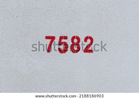Red Number 7582 on the white wall. Spray paint.
